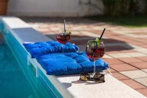 dos copas de vino sentadas en una cornisa junto a una piscina en Apartments Veramenta, en Cavtat