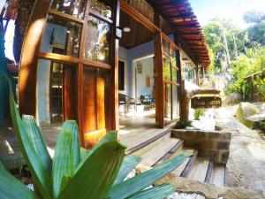 a house with a plant in front of it at Pousada Guapuruvu in Abraão