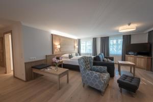 ザルツブルクにあるHotel Gasthof Mostwastlのベッドとリビングルームが備わるホテルルームです。