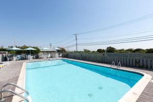 a swimming pool on a patio with a fence at Beach Plum Resort in Montauk