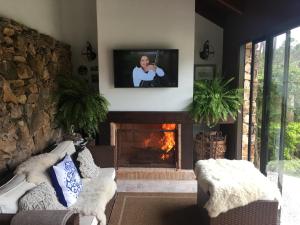 a living room with a fireplace and a tv at Bebek B&B in Punta del Este