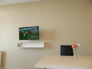 Cette chambre dispose d'une table et d'une télévision murale. dans l'établissement Апартамент с видом на море, à Batoumi