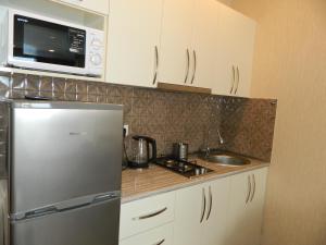 a kitchen with a stainless steel refrigerator and a microwave at Апартамент с видом на море in Batumi