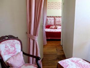 um corredor com uma cadeira e uma cama num quarto em Logis Hôtel Le Clos Pité em Préchacq