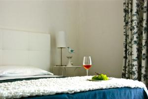 Una cama con una copa de vino y un plato de fruta. en B&B Dunedorate, en Punta Secca