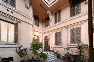 einen Innenhof eines Gebäudes mit Treppen und Pflanzen in der Unterkunft White Napoleone Apartment in Rom