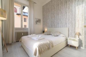 ein Schlafzimmer mit einem weißen Bett und Handtüchern darauf in der Unterkunft White Napoleone Apartment in Rom