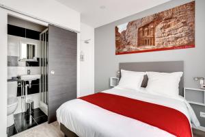 a bedroom with a large bed and a bathroom at Paris Hotel in Clichy