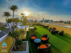 a rooftop patio with tables and chairs on a building at Siri Heritage Bangkok Hotel - SHA Extra Plus in Bangkok
