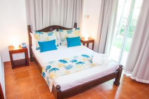 een slaapkamer met een bed met blauwe kussens bij Cocotal Bavaro Apartments in Punta Cana