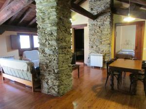 a living room with a stone pillar and a table at Can Bonada in El Serrat
