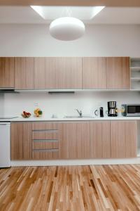 a kitchen with wooden cabinets and a hardwood floor at Luxury Apartments Zelny Trh in Brno