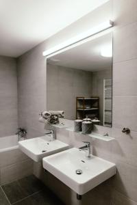 a bathroom with two sinks and a large mirror at Luxury Apartments Zelny Trh in Brno