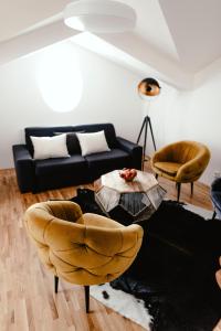 a living room with a couch and a table and chairs at Luxury Apartments Zelny Trh in Brno