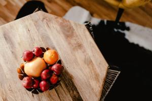 a bowl of fruit on a wooden cutting board at Luxury Apartments Zelny Trh in Brno