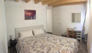 a bedroom with a bed and a desk and a table at South Lagoon Apartments 1 in Chioggia +6 photos