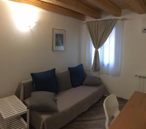 a living room with a couch and a window at South Lagoon Apartments 1 in Chioggia