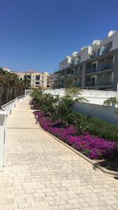 a walkway with purple flowers in front of a building at Buddha house in Torrox Costa