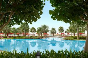 
a pool with a pool table and chairs in it at Khalidiya Palace Rayhaan by Rotana, Abu Dhabi in Abu Dhabi
