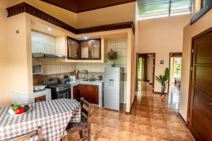 a kitchen with a table and a refrigerator at Aunty Arenal Lodge in Fortuna