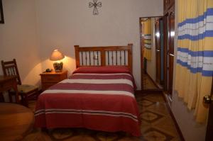 - une chambre dotée d'un lit avec une couverture rouge et blanche dans l'établissement Hotel Posada Escudero, à Oaxaca