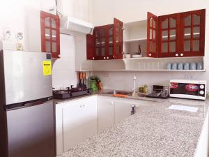 a kitchen with white cabinets and a refrigerator at MoonViews Apartment in Panglao
