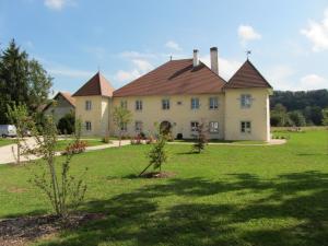 Casa grande con patio grande con césped verde en Le relais des deux tours, en Brémondans