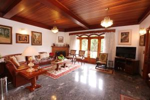 uma sala de estar com um sofá e uma TV em Pousada Recanto Paulista em Campos de Jordão