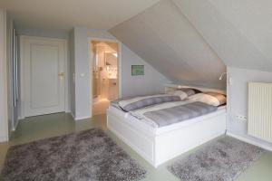 a bedroom with a white bed in a attic at Ferienhaus *Traumblick* in Wittdün