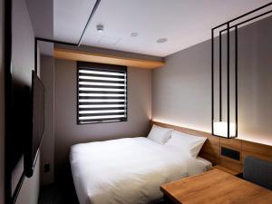 Giường trong phòng chung tại hotel androoms Shin-Osaka