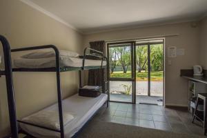 a room with two bunk beds and a door to a yard at Fiordland Great Views Holiday Park in Te Anau