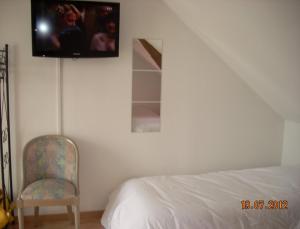 Vallères的住宿－薩爾住宿酒店，卧室配有一张床,墙上配有电视。