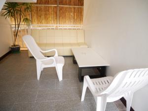 two white chairs and a table and a bench at Sabaidee mansion&hotel in Ko Lanta
