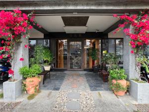 a front entrance to a building with flowers and plants at Key We Go Hotel 奇遇果人文旅店 in Tainan