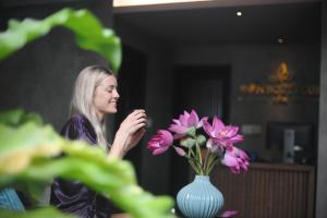une femme debout à côté d'un vase de fleurs dans l'établissement Sen Boutique Villa Apartment, à Đà Nẵng 38 autres photos