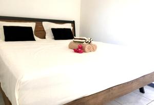 ein weißes Bett mit einer Handtasche darüber in der Unterkunft Iris suite in Punaauia