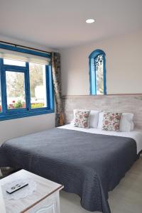 a bedroom with a large bed and two windows at La Casa Azul in Cuenca