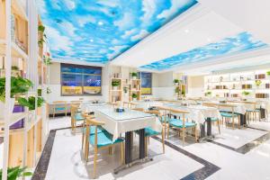a restaurant with a mural of clouds on the ceiling at Lingshang Hotel in Yiwu