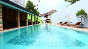 a large swimming pool with blue water in a building at Meotel Purwokerto in Purwokerto