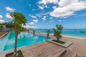 a swimming pool with a view of the ocean at O'Biches Beachfront Complex - Trou aux Biches in Trou aux Biches