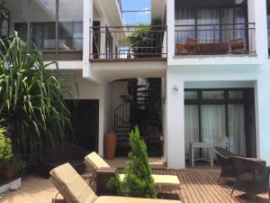 a building with a patio with chairs and a balcony at Villa Alizee in Port Louis