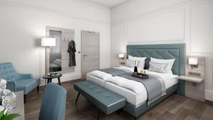 ein Schlafzimmer mit einem Kingsize-Bett und einem blauen Sessel in der Unterkunft Hotel Domhof in Speyer