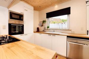 cocina con armarios blancos y encimera en Vakantiewoning Martha, en Veurne