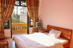 a bedroom with a bed and a tv and a window at Thanh Ha Homestay Sapa in Sapa