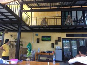 a person standing in a restaurant with a table at Baan Rabieng Talay Homestayบ้านระเบียงทะเล โฮมสเตย์เกาะกูด in Ko Kood
