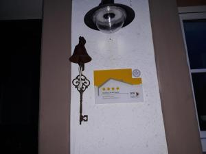 Una luz en una pared con una señal. en Eifelferienhaus An der Kapelle - kostenlose Sauna, Ofen, en Kerschenbach