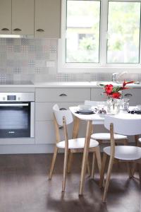 a white kitchen with a white table and chairs at Island Cottages in Nelly Bay