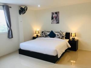 um quarto com uma cama com dois candeeiros e uma imagem na parede em Baba Guest House em Kamala Beach