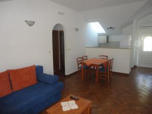 ein Wohnzimmer mit einer blauen Couch und einem Tisch in der Unterkunft Apartments Marija in Slano