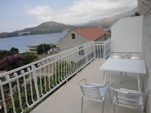 einen Balkon mit Stühlen, einem Tisch und Blick auf das Wasser in der Unterkunft Apartments Marija in Slano